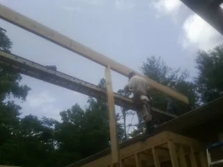 Carpenter setting a ridge beam over a new addition frame — Ice Dam Removal by Roofing Brothers in Verndale