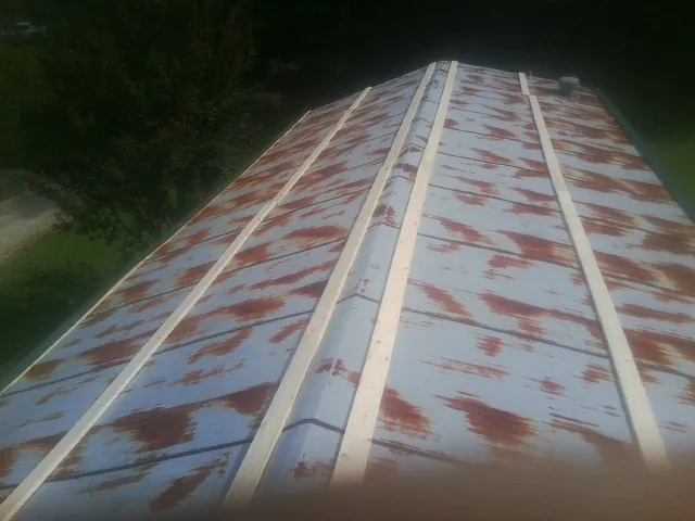 Rusted metal roof panels with new wood purlins before replacement — Storm Damage Roof Repair in Verndale by Roofing Brothers