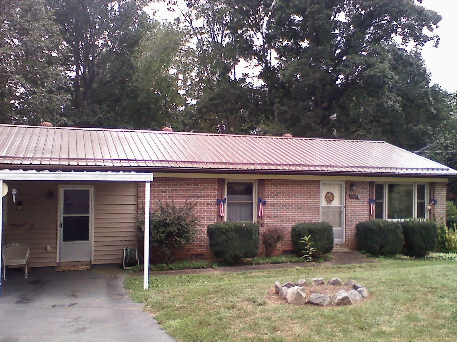 Bronze metal roof and carport on a brick ranch home — Roof Repair work by our crew in Verndale